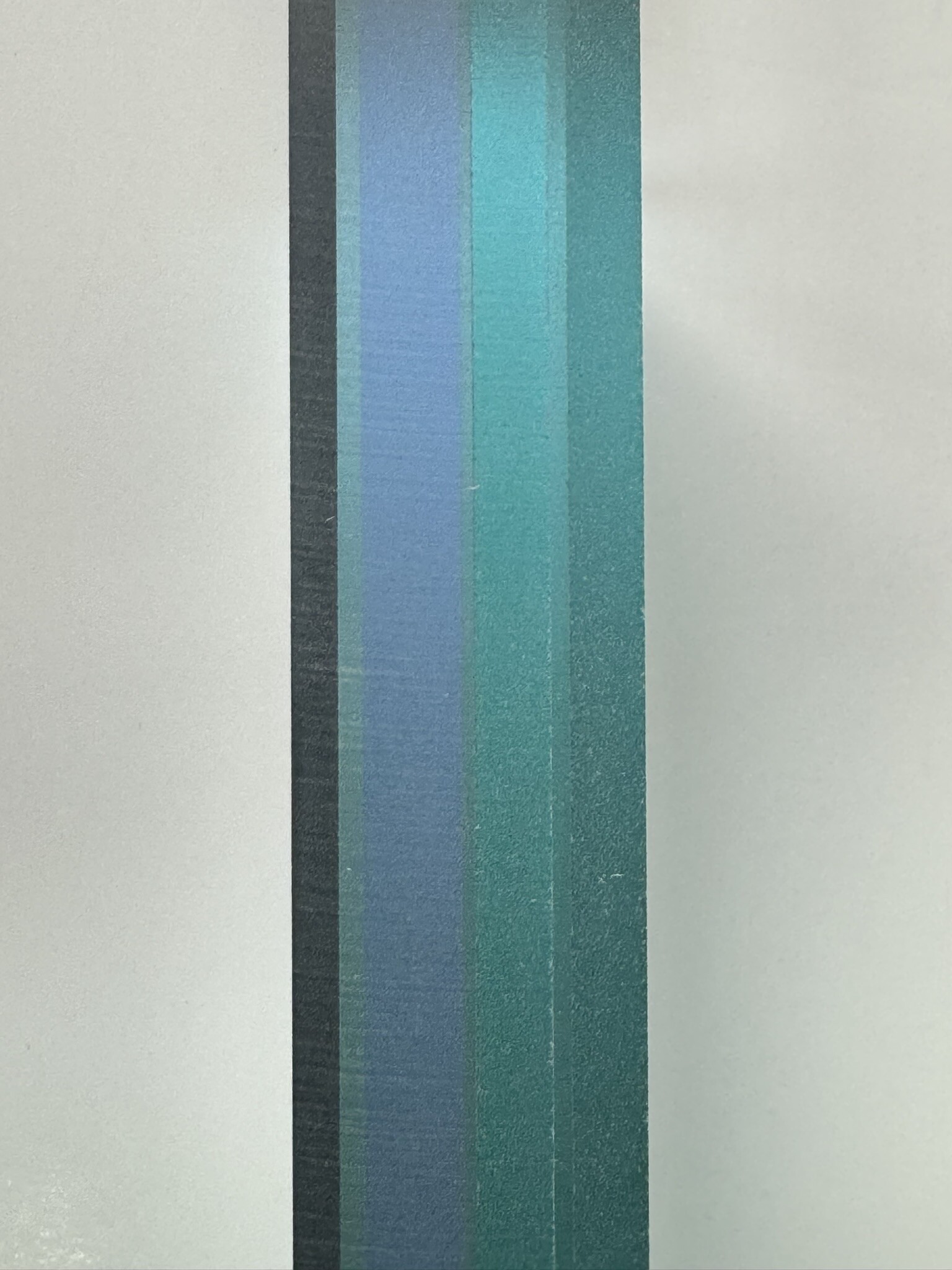 Edge profile of BallistiMAX glass-clad polycarbonate — the layered laminate stack viewed side-on, 1.6 inches thick.
